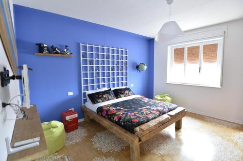 een slaapkamer met een blauwe muur met een bed erin bij AgriCesar in San Lorenzo