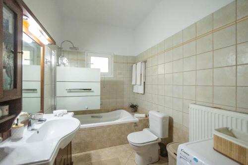 a bathroom with a sink and a toilet and a tub at Elpida's country house in Lefkimmi
