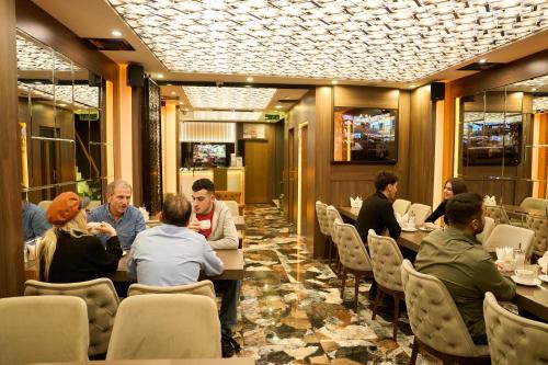 un grupo de personas sentadas en mesas en un restaurante en Bonne Sante Hotel, en Estambul