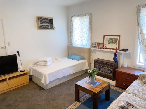 a bedroom with a bed and a tv and a couch at Comfy Private rooms in Braybrook in Braybrook