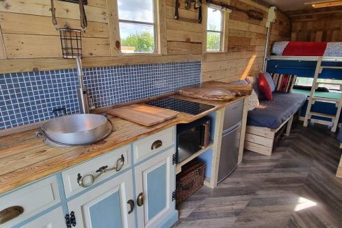 a kitchen with a counter with a sink and a stove at Celaeron Glamping in Aberaeron