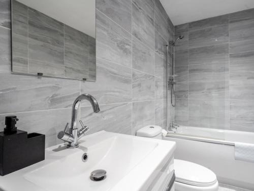 a white bathroom with a sink and a toilet at Pass the Keys Serenity in the Suburbs - Modern 2BR Apartment in Liverpool