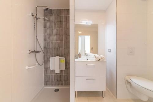 a white bathroom with a shower and a sink at OVELIA Les Angles - Les Loges d'Anicet in Les Angles Gard