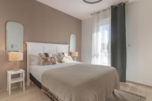 um quarto com uma cama grande e uma janela em OVELIA Les Angles - Les Loges d'Anicet em Les Angles Gard