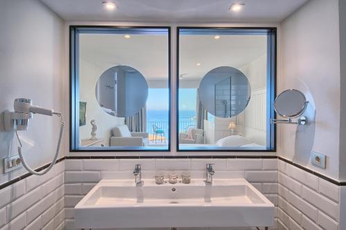 a bathroom with a sink and a large window at Hotel Aigua Blava in Begur