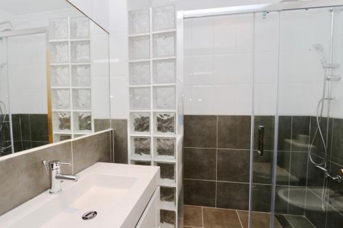 uma casa de banho com um lavatório e uma cabina de duche em vidro. em Villa Molgard 61 - Clever Details em Vilamoura
