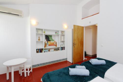2 łóżka w pokoju ze stołem i biurkiem w obiekcie Villa Molgard 61 - Clever Details w mieście Vilamoura