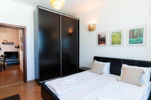a bedroom with a bed with a black headboard at Rezident Eforie Nord in Eforie Nord