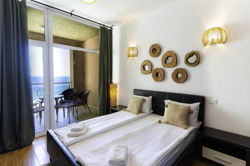 a bedroom with a large bed and a balcony at Rezident Eforie Nord in Eforie Nord