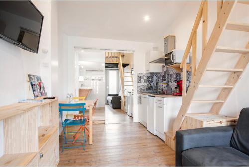 une pièce avec une cuisine et un salon avec escalier dans l'établissement Villa des palmiers, Studio cosy, à Villeneuve-sur-Lot