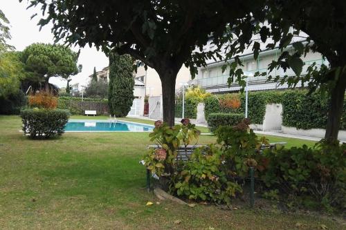 a garden with a bench and a swimming pool at Apartmento Duplex in S'agaro