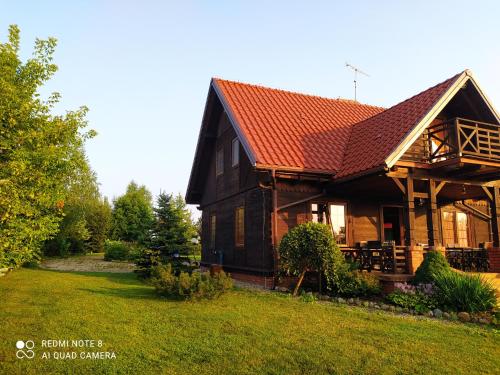 a large wooden house with a red roof at Dom z bala kort tenisowy ,linia brzegowa plaża ,pomost ,kajaki, łódka in Krzywe