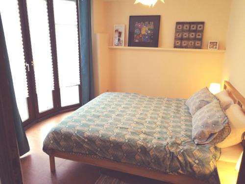 een slaapkamer met een bed in een kamer met ramen bij Triplex près de la Grand-Place in Brussel