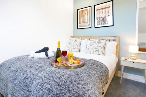 a bed with a tray of food and a bottle of wine at Central Buckingham Apartment #8 with Free Parking, Pool Table, Fast Wifi and Smart TV with Netflix by Yoko Property in Buckingham