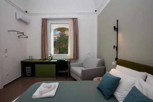 a bedroom with a bed and a desk and a chair at La Corte del Fante in Marsala