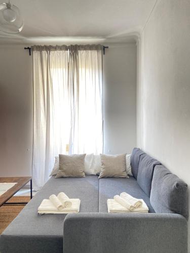 a living room with a blue couch and a window at Paolina Home in La Spezia