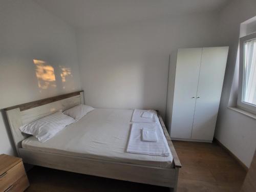 a small bedroom with a bed and a white cabinet at Apartman MatiNik in Mionica