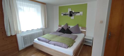sypialnia z łóżkiem z zielonymi ścianami i oknem w obiekcie Haus Alpenrose w mieście St. Leonhard im Pitztal
