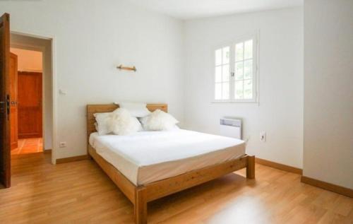 - une chambre avec un lit doté de draps blancs et une fenêtre dans l'établissement Magnifique Maison avec piscine sans vis à vis 4 chambres et 1 mezzanine dans un milieu verdoyant, à Saint-Jean-du-Gard