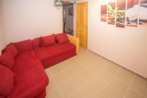 una sala de estar con un sofá rojo en una habitación en Otthon A Pagonyban, en Mátraszentimre