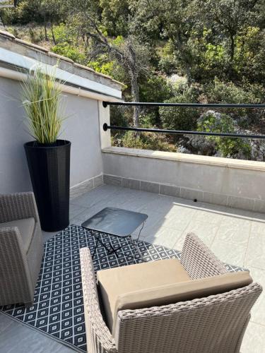 a patio with a table and chairs on a balcony at Gîte des Estelles "Alixia" in Cavaillon