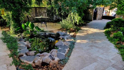 a garden with a pond with rocks and a fence at Charming modern country unit for rent in Tarum