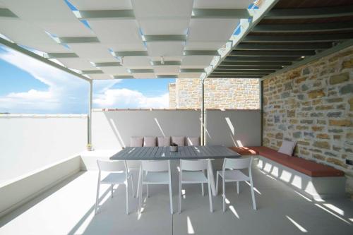 a dining room with a table and chairs on a balcony at Afentiko Pigadi in Methoni