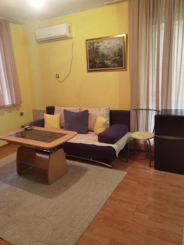 een woonkamer met een bank en een tafel bij Гарсониера in Stara Zagora