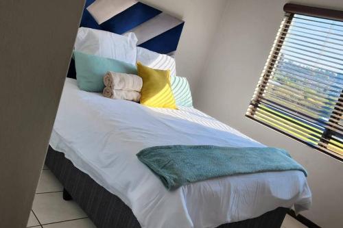 1 dormitorio con 1 cama grande y almohadas coloridas en Stunning Golf Course view en Roodepoort