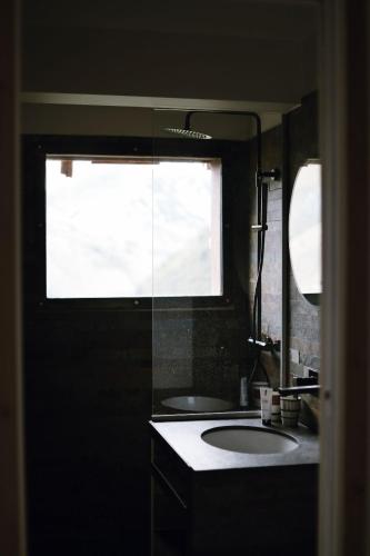 a bathroom with a sink and a large window at Les Cèdres - Hôtel - Restaurants - Spa in Saint-Sorlin-dʼArves