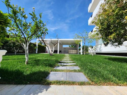 um jardim relvado com um caminho em frente a um edifício em Vila Anxhelo&Xhemi em Vlorë