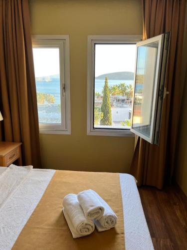 a bedroom with two towels on a bed with two windows at EXEN BY WEEKEND in Bodrum City