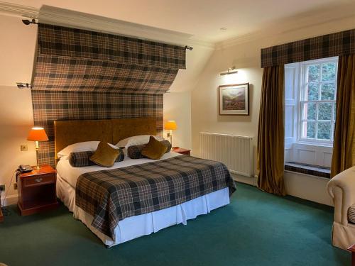 a hotel room with a bed and a window at Bunchrew House Hotel in Inverness