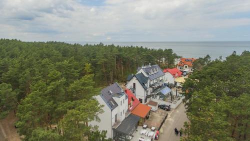 an aerial view of a town with trees and the ocean at uTadka in Sztutowo