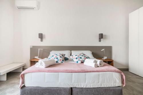 una camera da letto con un grande letto bianco con cuscini di Villa Licari Stagnone a Marsala