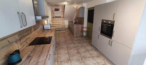 Il comprend une cuisine avec des placards blancs et du parquet. dans l'établissement Les gîtes d'Argentin, à Lièpvre