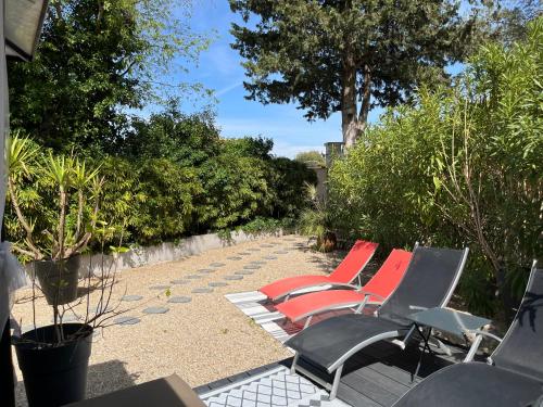 a row of lawn chairs sitting on a patio at Gîte des Estelles "Alixia" in Cavaillon
