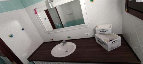 Sardegna Porto San Paolo في بورتو سان باولو: حمام مع حوض ومرحاض ومرآة