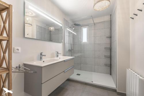Un baño blanco con lavabo y ducha. en Villa Rose des sables, en Arcachon