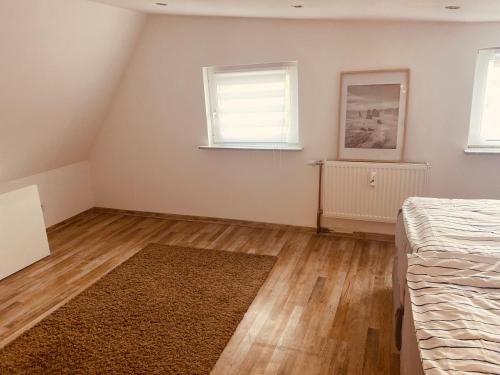 a bedroom with a bed and a wooden floor at Ferienwohnung Horst 2 in Nordenham
