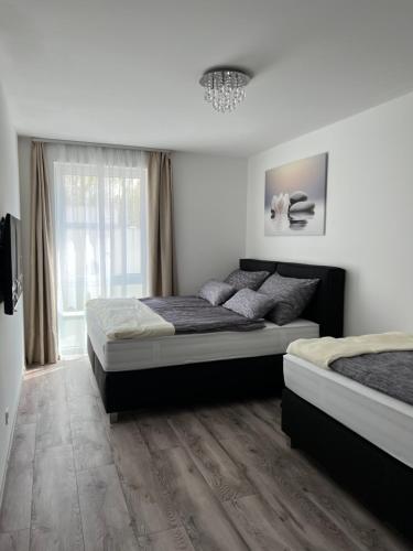 a bedroom with two beds and a window at Villa Bauhaus Dream Deluxe T in Siófok