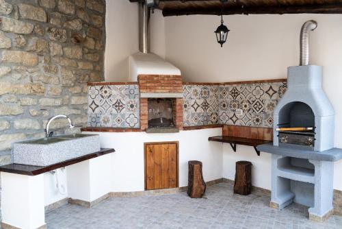 una cucina con lavandino e forno di B&B Tenuta Piano Campo a Ucria