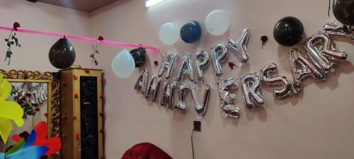 a wall with balloons spelling out the word happy at Hotel Shelton Palace in Multan
