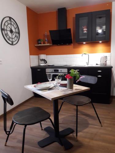 une cuisine avec une table et deux chaises et une cuisine avec un évier dans l'établissement iSABELLE, à Vannes