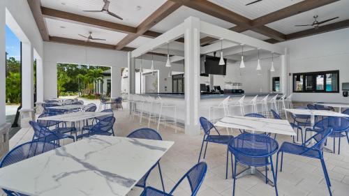 a dining room with tables and chairs and a kitchen at Modern Luxury Villa with Everything in Kissimmee