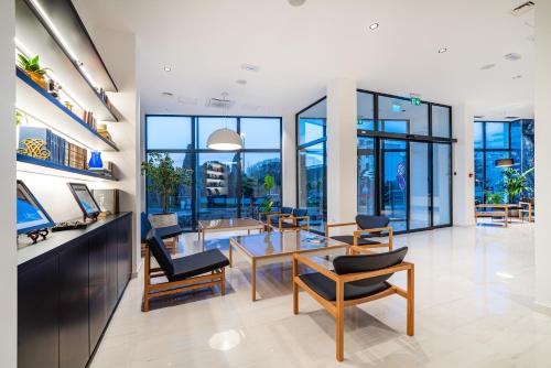 a lobby with a table and chairs and windows at Miramare Hotel in Zadar