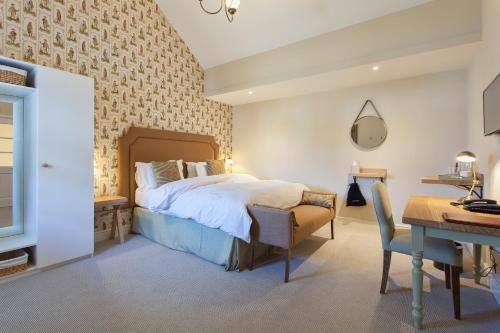 um quarto com uma cama e uma secretária. em The Inn West End em Woking