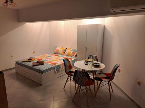 a bedroom with a bed and a table and chairs at Victory in Stara Zagora