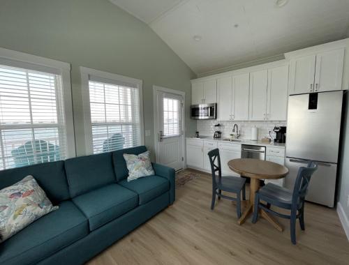 a living room with a blue couch and a kitchen at Key West Cottages in Chincoteague