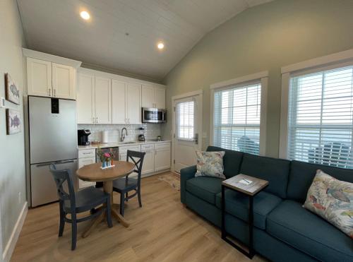 a living room with a blue couch and a kitchen at Key West Cottages in Chincoteague